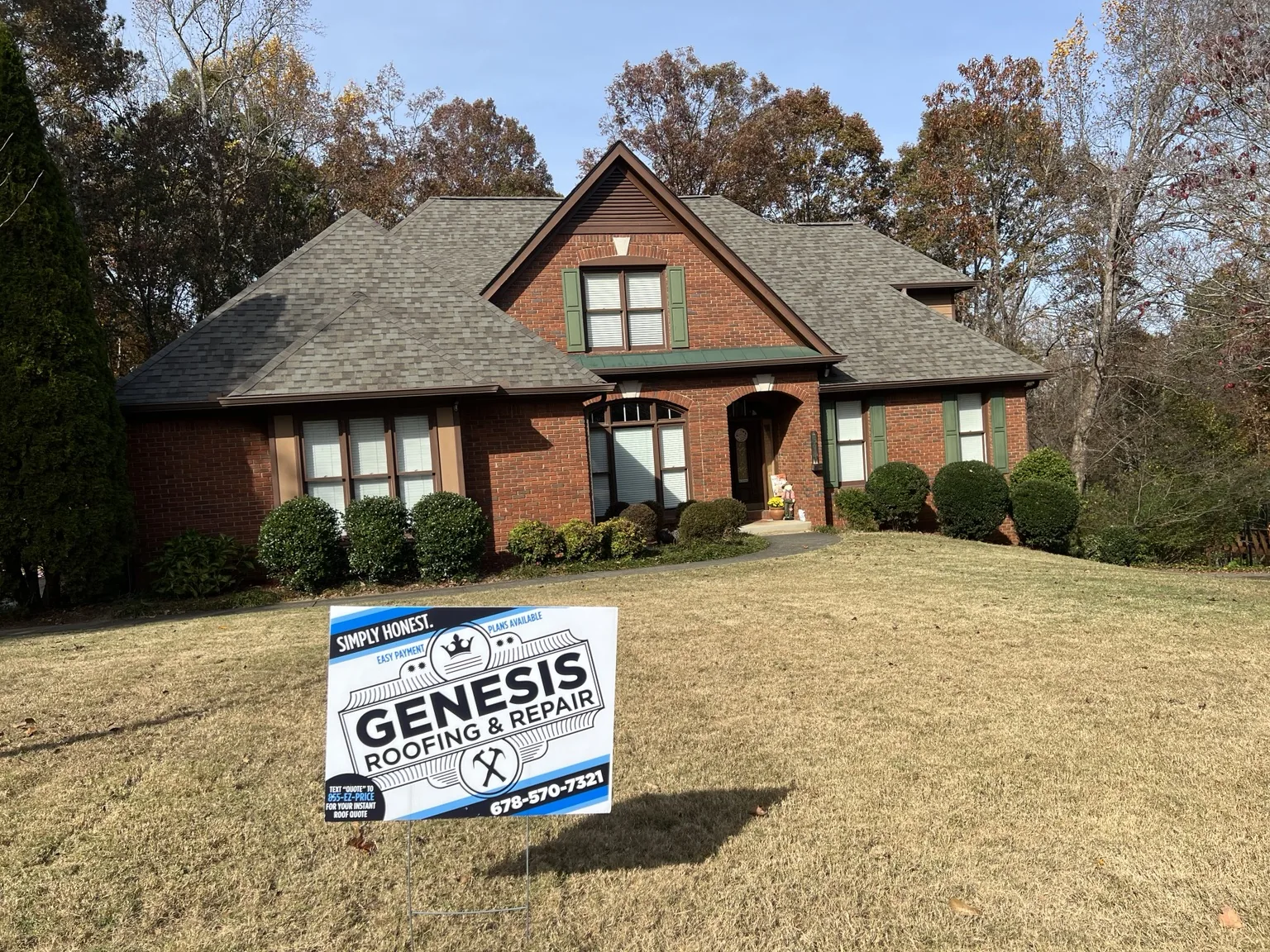 Completed architectural shingle roof with Genesis Roofing sign