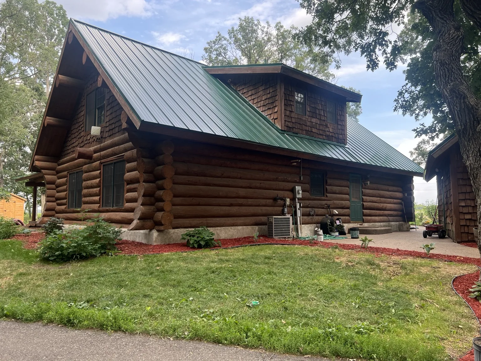 Completed green metal roof on a log home