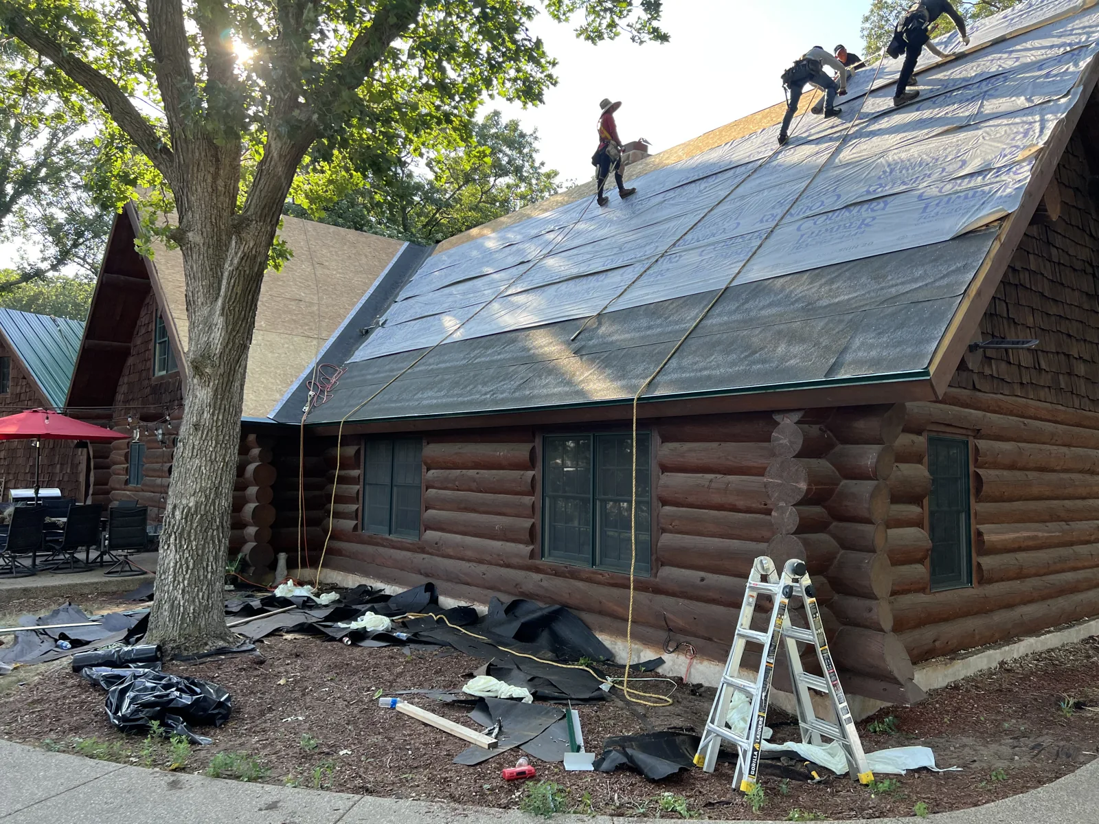 Roofing crew working on the log home before the metal panels are installed