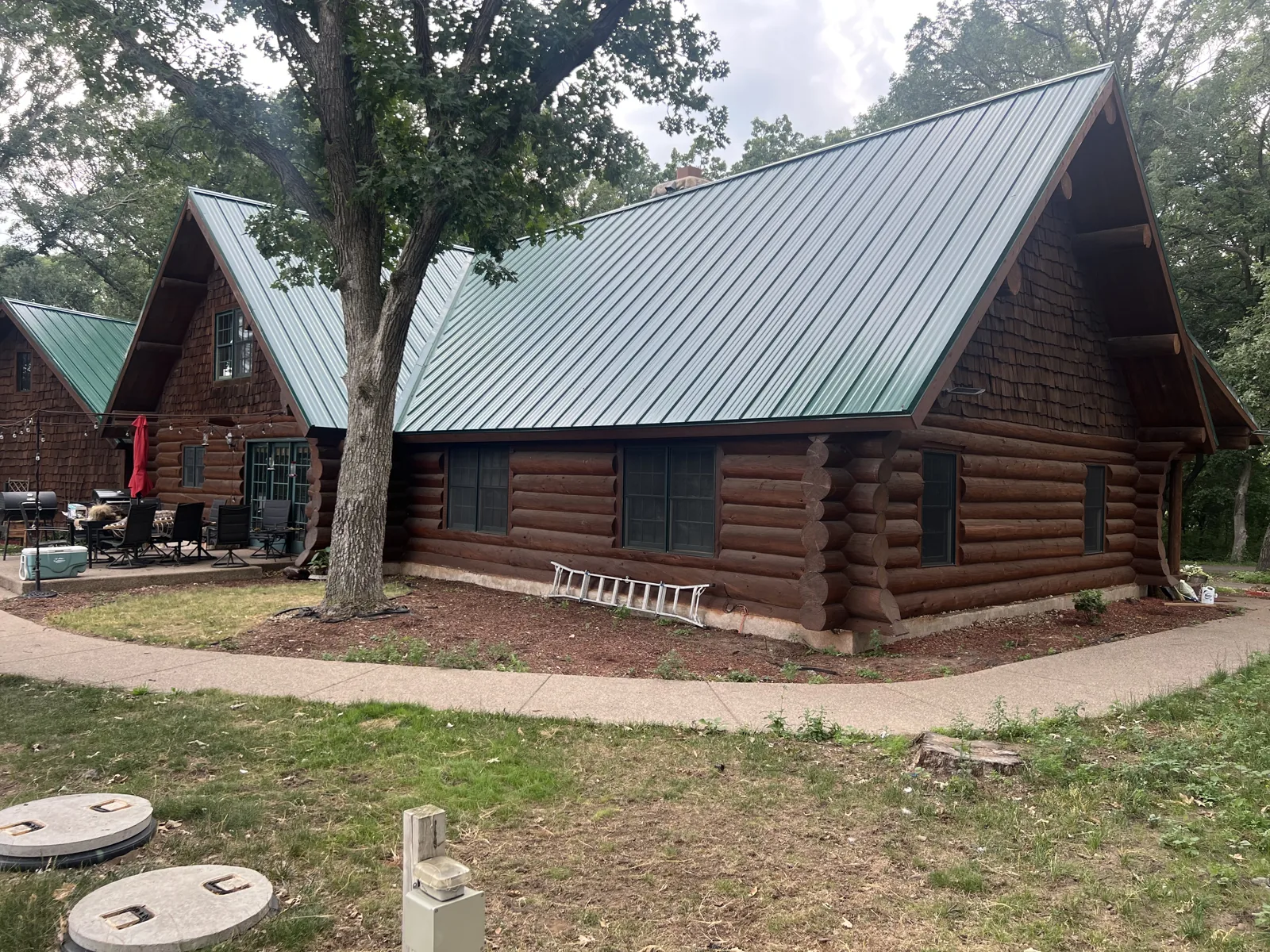 Completed green metal roof on a log home