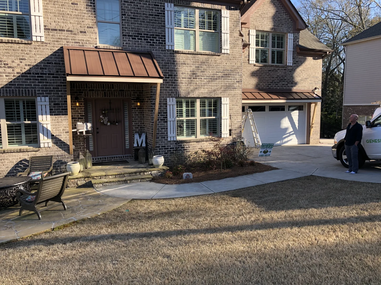 Copper-toned metal roofs over the entrance and garage of a brick home